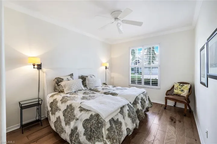 Bedroom with twin beds crown molding, dark hardwood / floors, and ceiling fan Crown Molding.