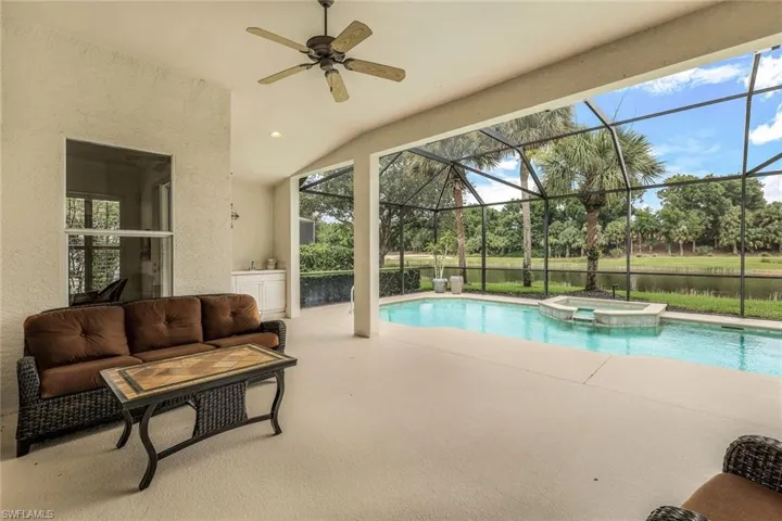 View of swimming pool featuring ceiling fan, a patio, an in ground hot tub, a lanai, and an outdoor living space