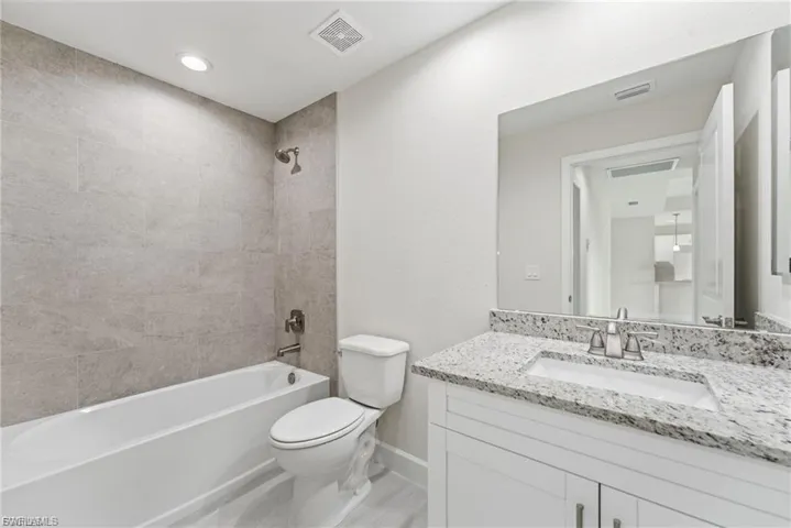 Full bathroom with bathtub / shower combination, vanity, and recessed lighting