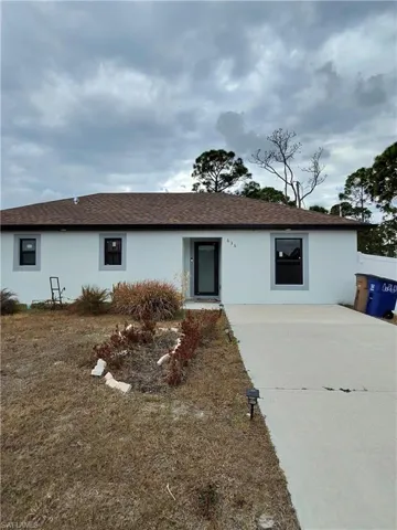 Ranch-style home with stucco siding, roof with shingles, and driveway