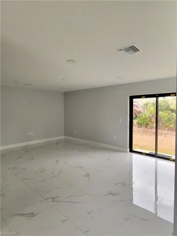 Spare room featuring baseboards and light marble finish floors