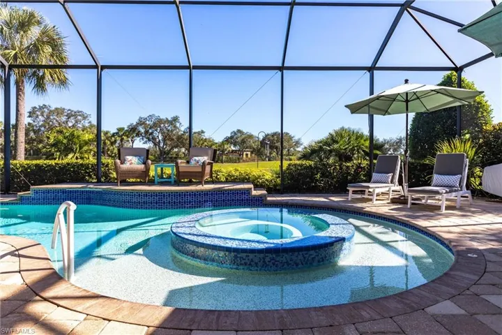 View of swimming pool with a pool with connected hot tub, glass enclosure, and a sunroom