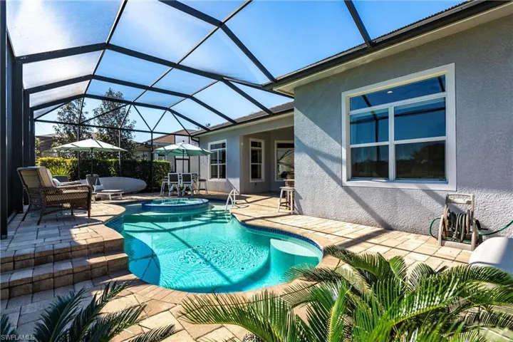 View of swimming pool with a patio, a sunroom, a lanai, and a pool with connected hot tub