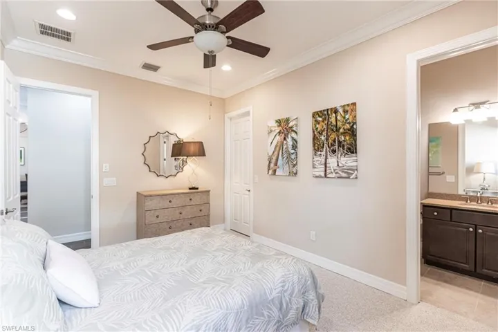 Bedroom with crown molding, ensuite bathroom, light colored carpet, recessed lighting, and a ceiling fan