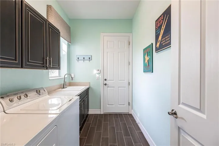 Laundry room with cabinet space, wood tiled floors, and washing machine and dryer