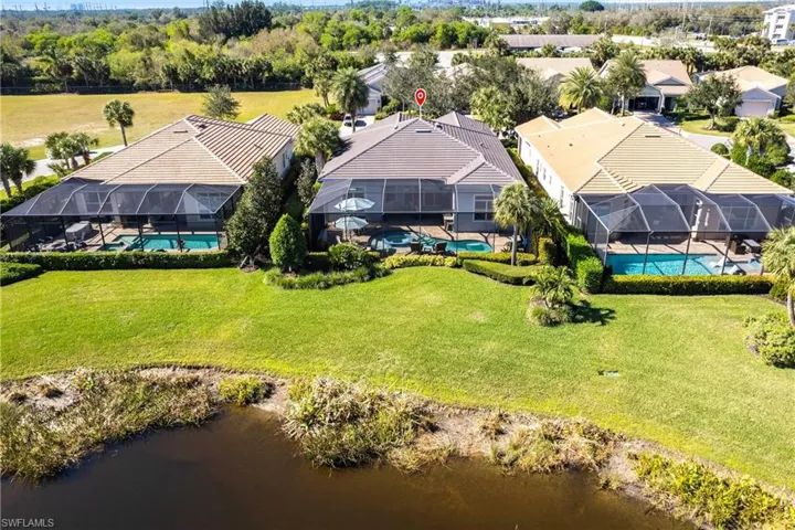Aerial view of property and surrounding area with a pool area and a nearby body of water