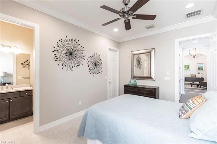 Bedroom with crown molding, connected bathroom, light colored carpet, ceiling fan, and recessed lighting