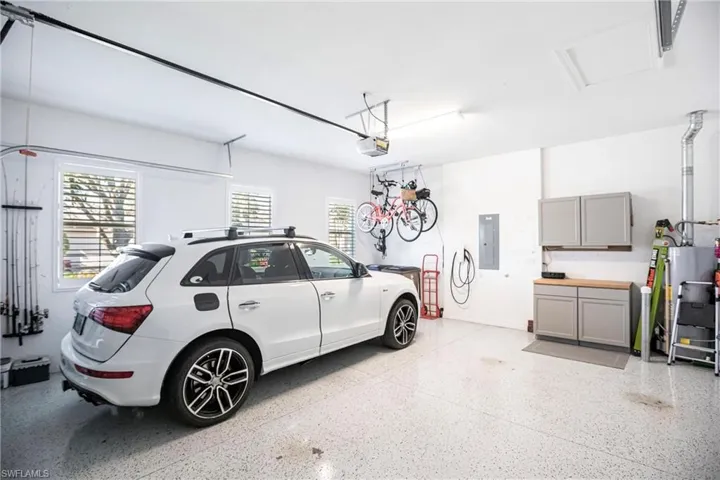 Garage featuring gas water heater and electric panel