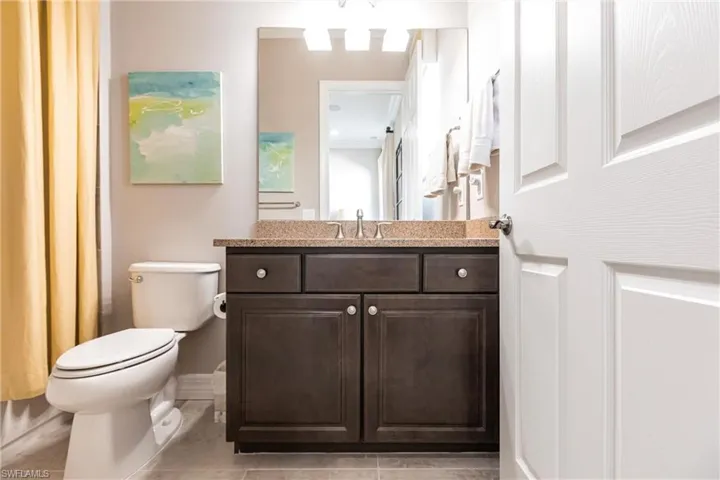 Full bathroom featuring vanity, light tile patterned flooring, and a shower with shower curtain