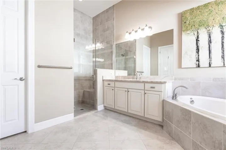 Full bath with a bath, a shower stall, light tile patterned floors, and vanity