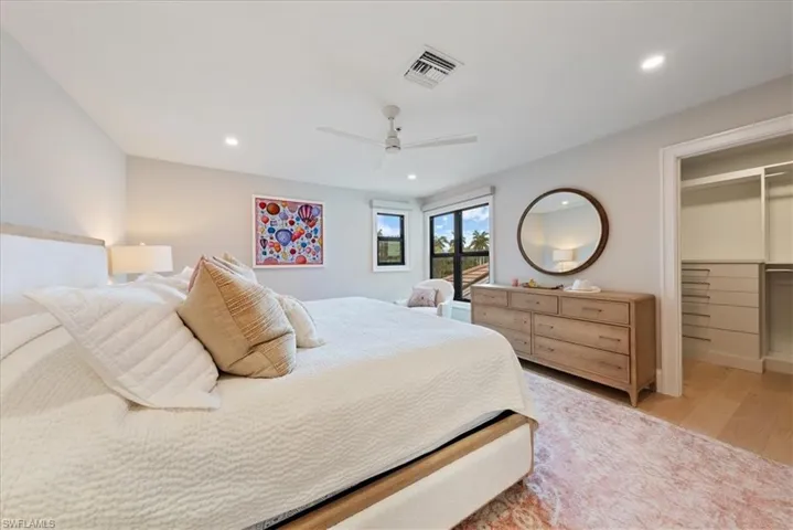 Bedroom with a closet, ceiling fan, light wood-type flooring, and a walk in closet