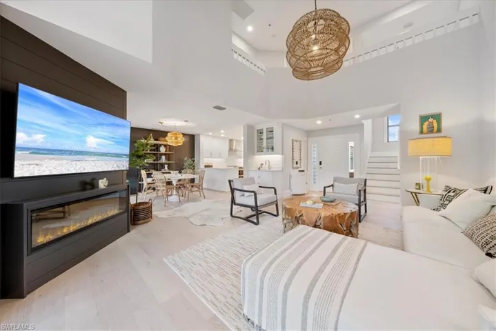 Living room featuring light hardwood / wood-style floors and a towering ceiling