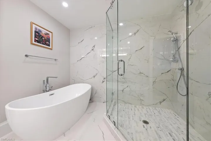Bathroom with plus walk in shower, tile patterned flooring, and tile walls