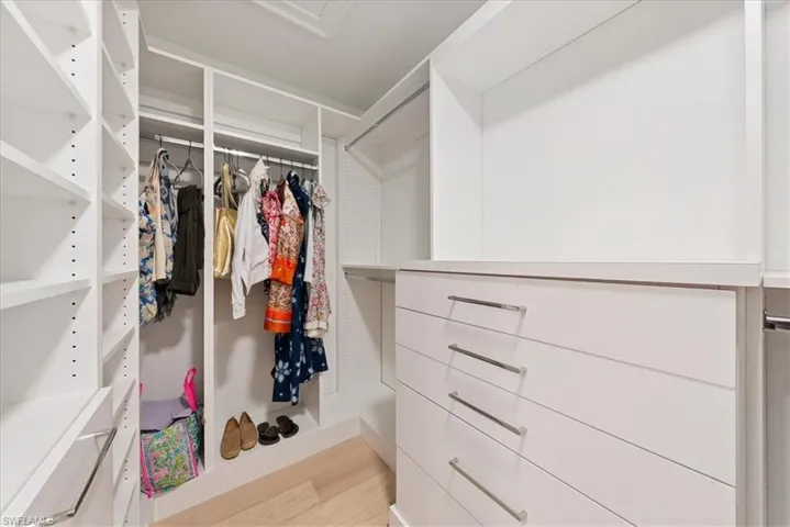 Spacious closet with light hardwood / wood-style flooring