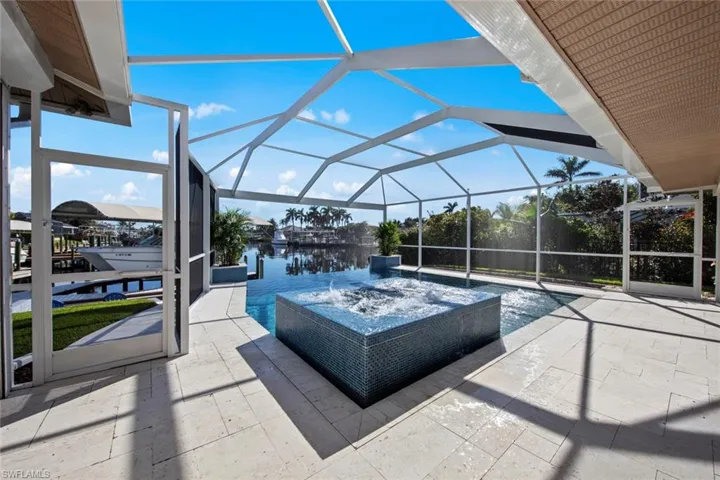 View of patio featuring a lanai, a water view, and pool water feature