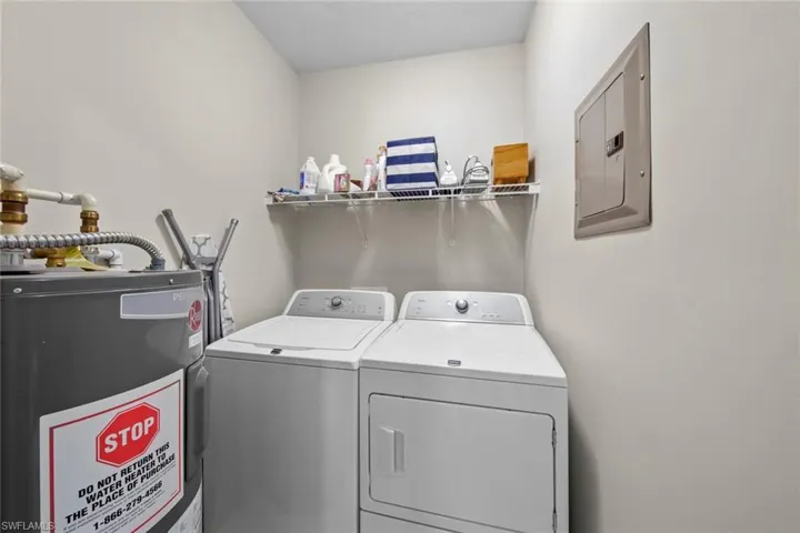 Washroom with electric panel, water heater, and washing machine and dryer