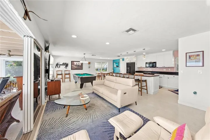 Living room with ceiling fan, plenty of natural light, and pool table