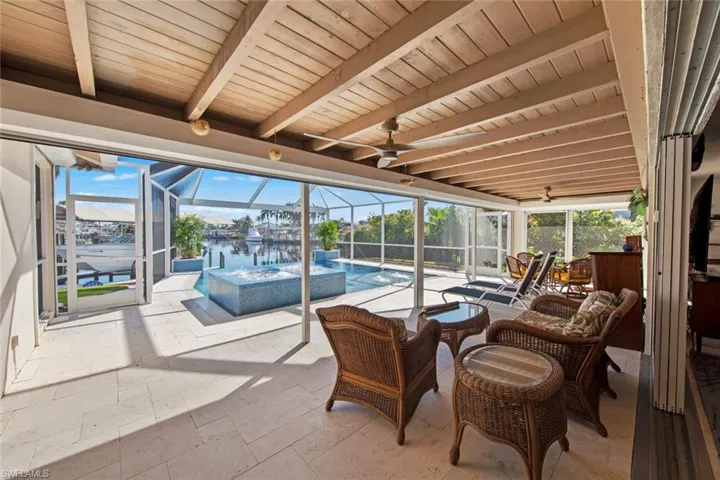 Sunroom featuring beamed ceiling, a healthy amount of sunlight, a water view, and wooden ceiling