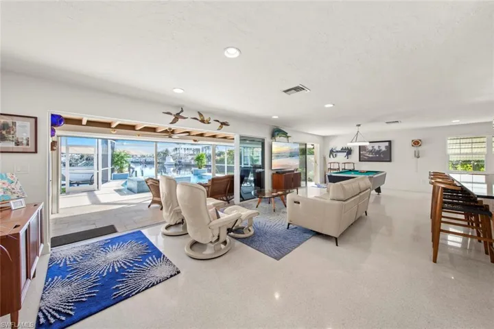 Living room with a wealth of natural light, a textured ceiling, and billiards