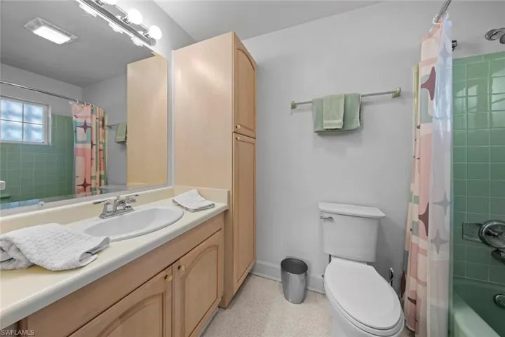 Full bathroom featuring vanity, shower / bathtub combination with curtain, and toilet