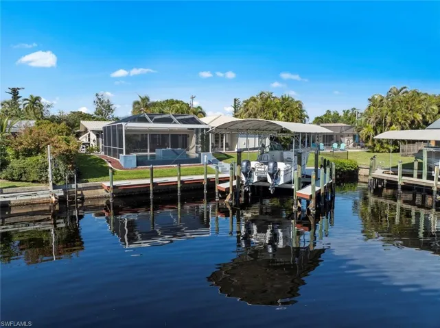 View of dock with a lanai and a water view