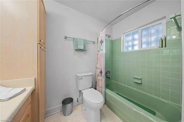 Full bathroom with vanity, toilet, and shower / bath combo with shower curtain