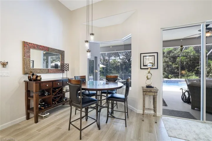 Dining space with a high ceiling, ceiling fan, and light hardwood / wood-style floors