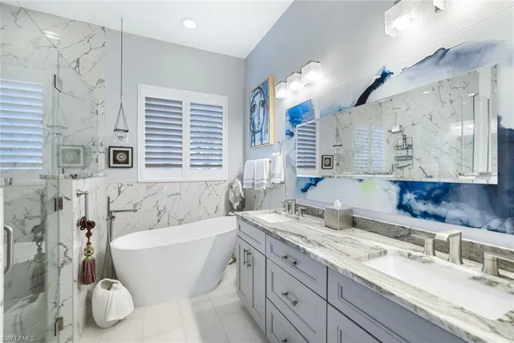 Bathroom featuring vanity, a wealth of natural light, and separate shower and tub