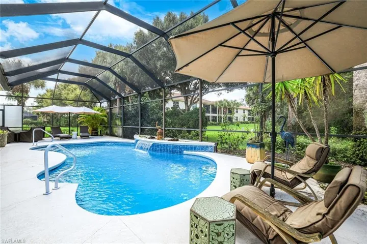 View of swimming pool featuring a patio area, pool water feature, and a lanai