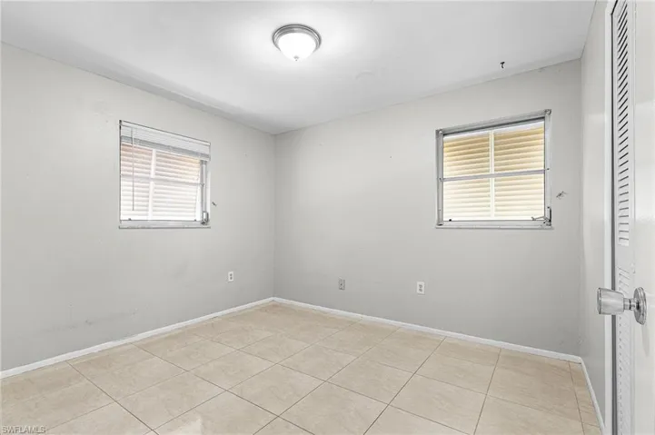 Empty room featuring light tile patterned floors and baseboards