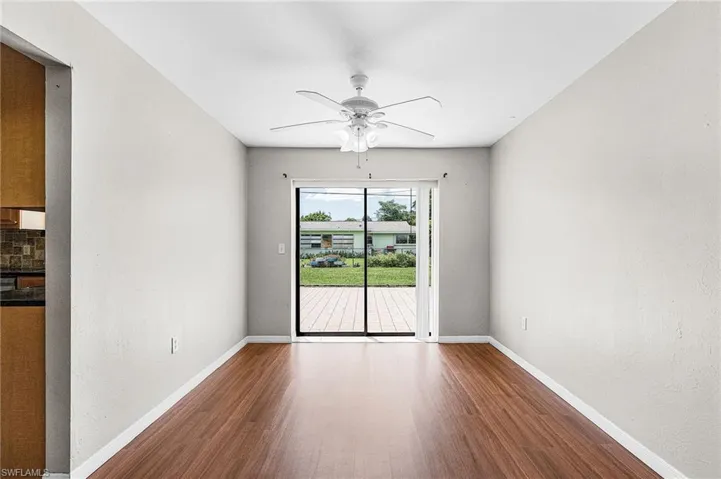 Unfurnished room featuring dark wood-type flooring, a textured wall, and ceiling fan