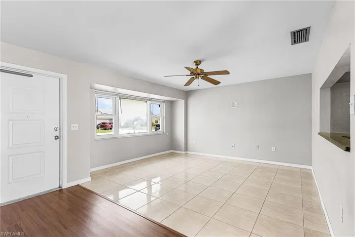 Foyer with a ceiling fan and light tile patterned floors