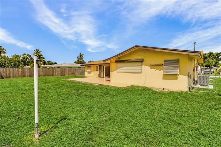 Rear view of property with a fenced backyard, stucco siding, and a patio area