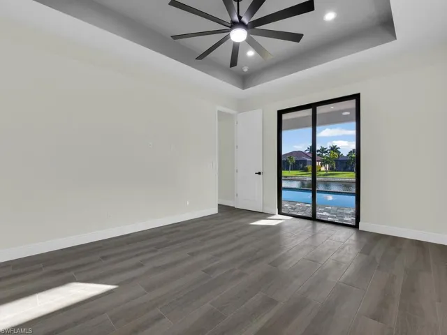 Unfurnished room with a raised ceiling, wood tiled