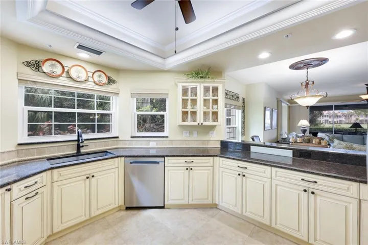 Kitchen with dishwasher, cream cabinets, crown molding, and sink