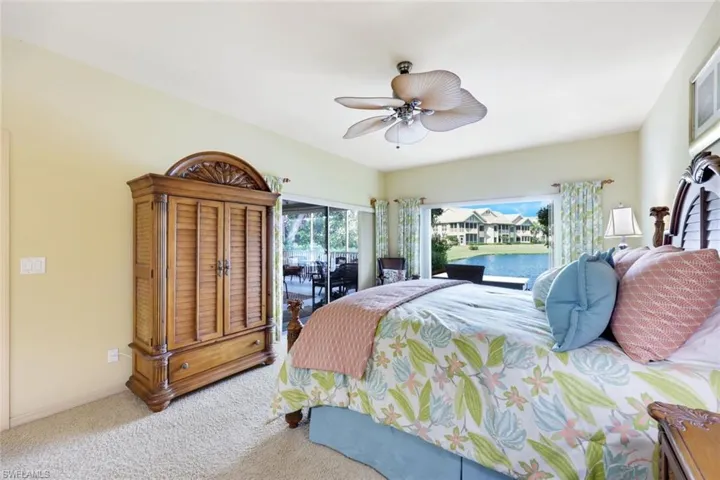 Carpeted bedroom featuring ceiling fan and access to exterior