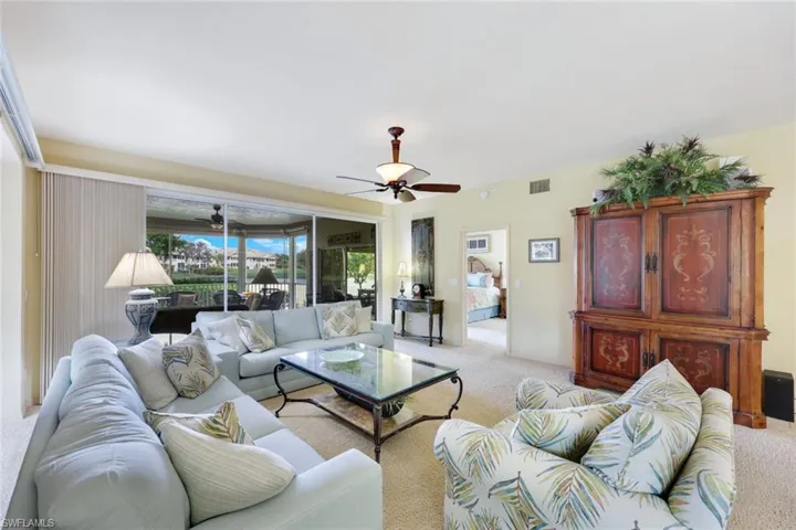 Carpeted living room with ceiling fan