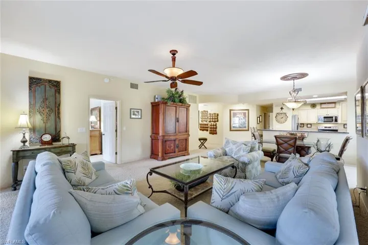 Living room featuring ceiling fan and light carpet