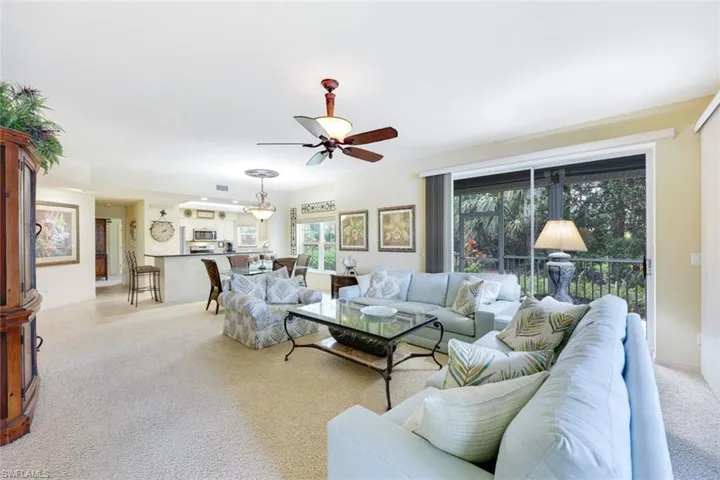 Carpeted living room with ceiling fan