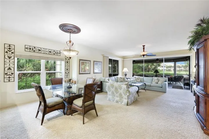 Carpeted dining space featuring plenty of natural light and ceiling fan
