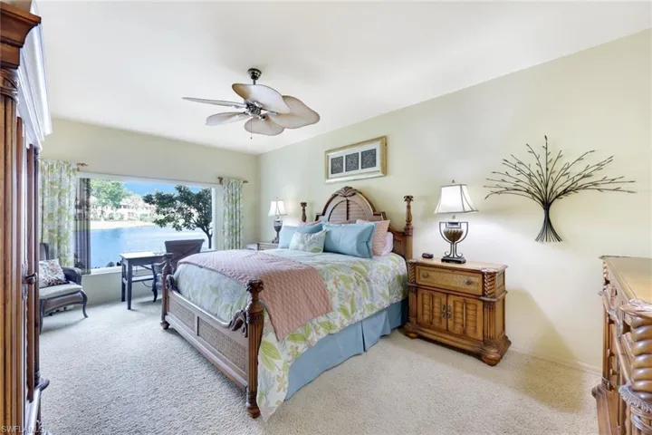 Carpeted bedroom featuring ceiling fan