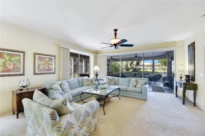 Living room with light carpet and ceiling fan