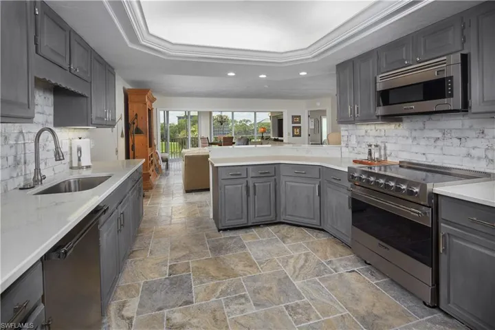 This spacious kitchen features wood cabinetry, stainless steel appliances and ample counter space formeal preparation.