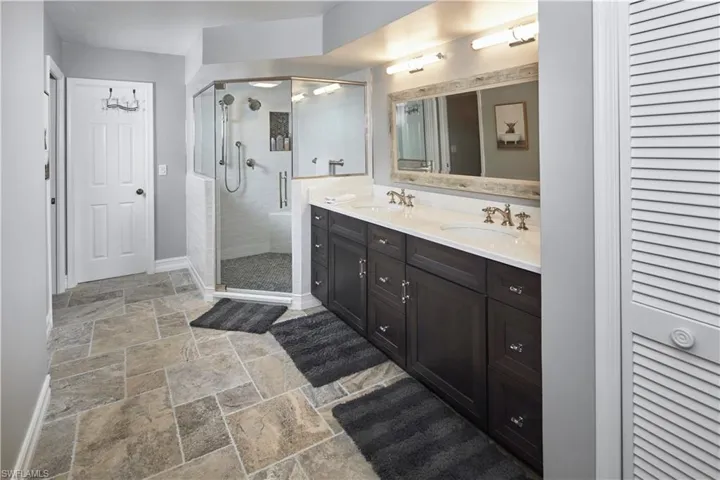 Primary en suite bathroom with dual sinks and walk in shower.