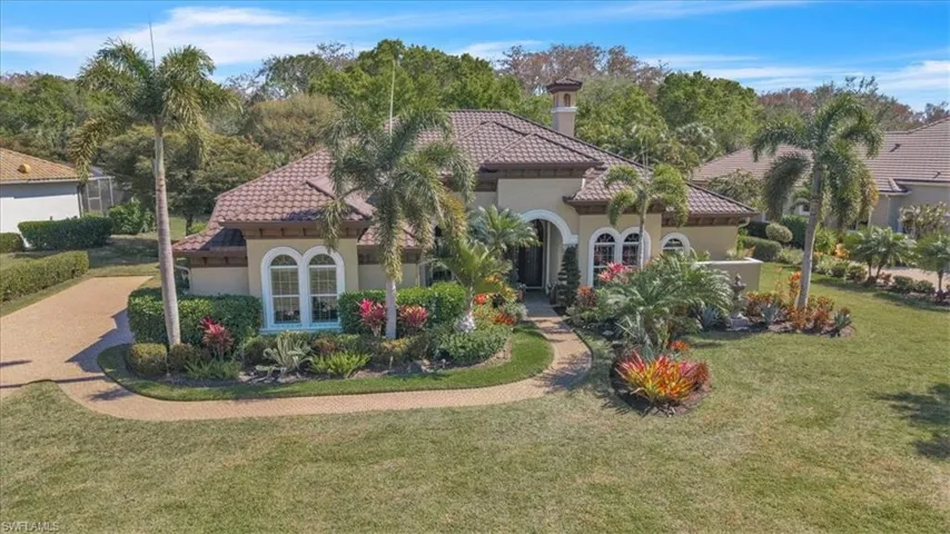View of front of house featuring a front yard, a tile roof, and stucco siding
