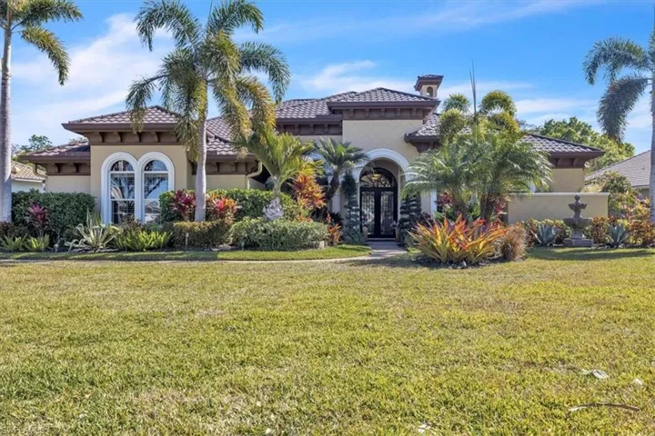 Mediterranean / spanish house with a front yard, stucco siding, a tiled roof, and french doors
