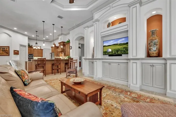 Living area featuring ornamental molding, recessed lighting, and arched walkways