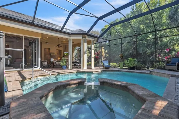 Combined pool / hot tub with a sunroom, a patio area, and glass enclosure