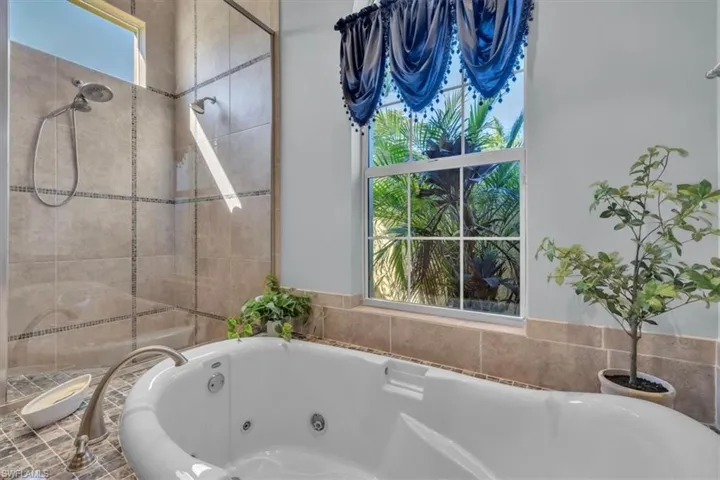 Bathroom featuring a shower stall and a whirlpool tub