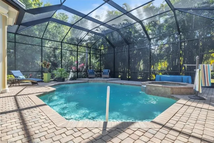 Integrated pool / hot tub featuring glass enclosure, a patio, and a sunroom